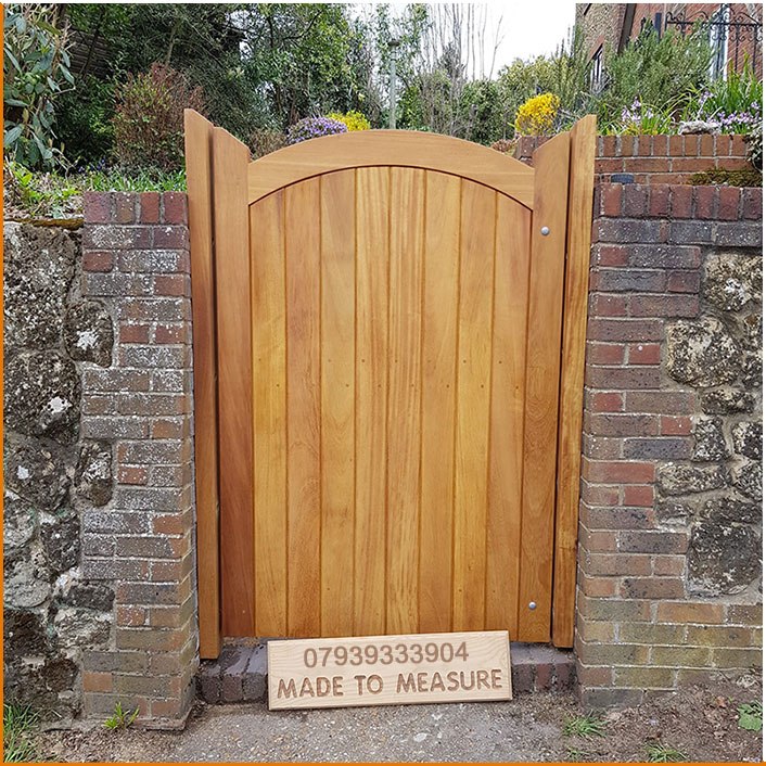 Arched timber garden gate fitted in a garden entrance